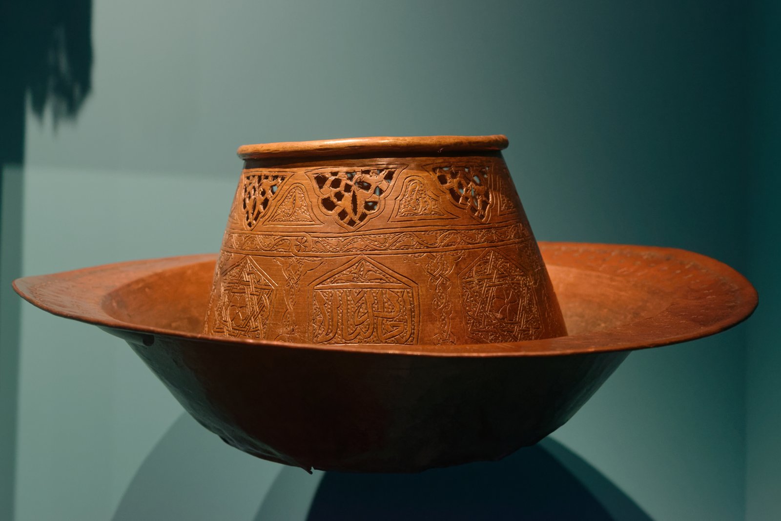 A Funj-style ceramic plate alongside a Mamluk-style metal container, held at Sudan's National Corporation for Antiquities and Museums