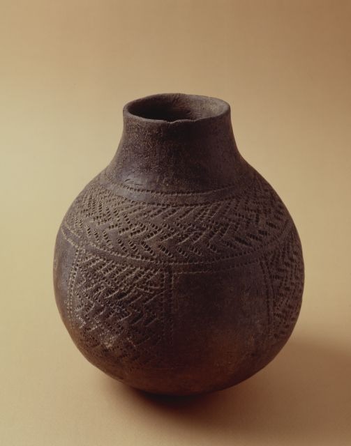 Dark round-bottomed pottery jar with a short neck and impressed geometric decoration.